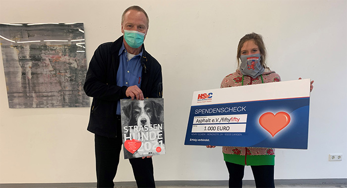 Detlev Fellmann, Gebietsverkaufsleiter NRW bei Henry Schein Dental Deutschland GmbH und Julia von Lindern vom Straßenmagazin fiftyfifty bei der Scheckübergabe.